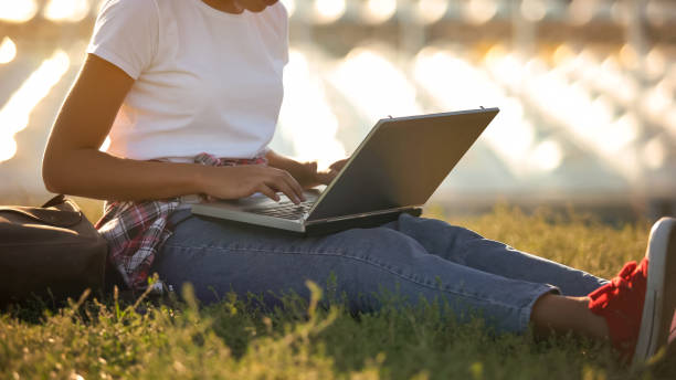 istock African american student typing on laptop, sitting on lawn, working on project 1143237973