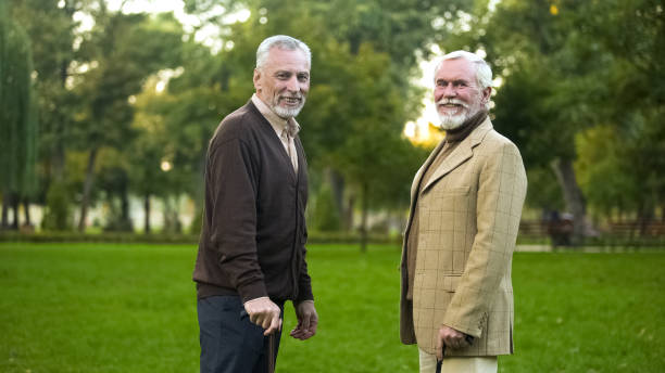 istock Aged men with walking sticks resting and smiling for camera, male friendship 1143239574
