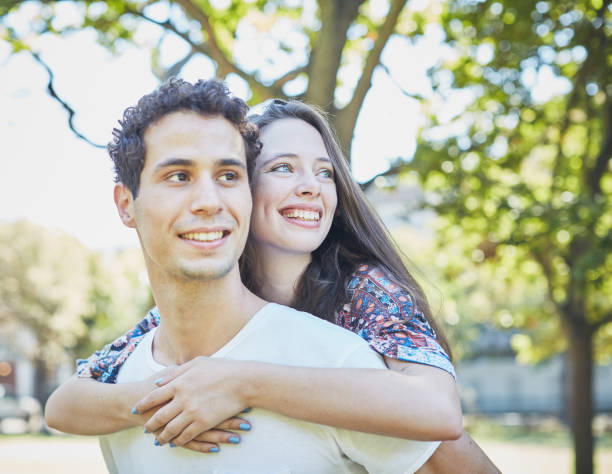 istock Smiling young couple embracing in leafy park 1143240111