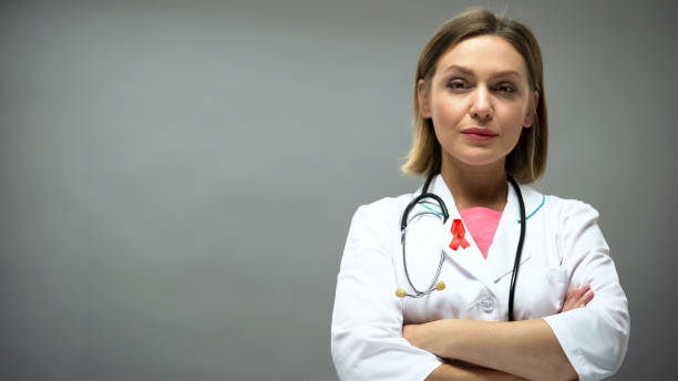 istock Confident doctor with red ribbon looking into camera, hiv aids awareness 1143240117