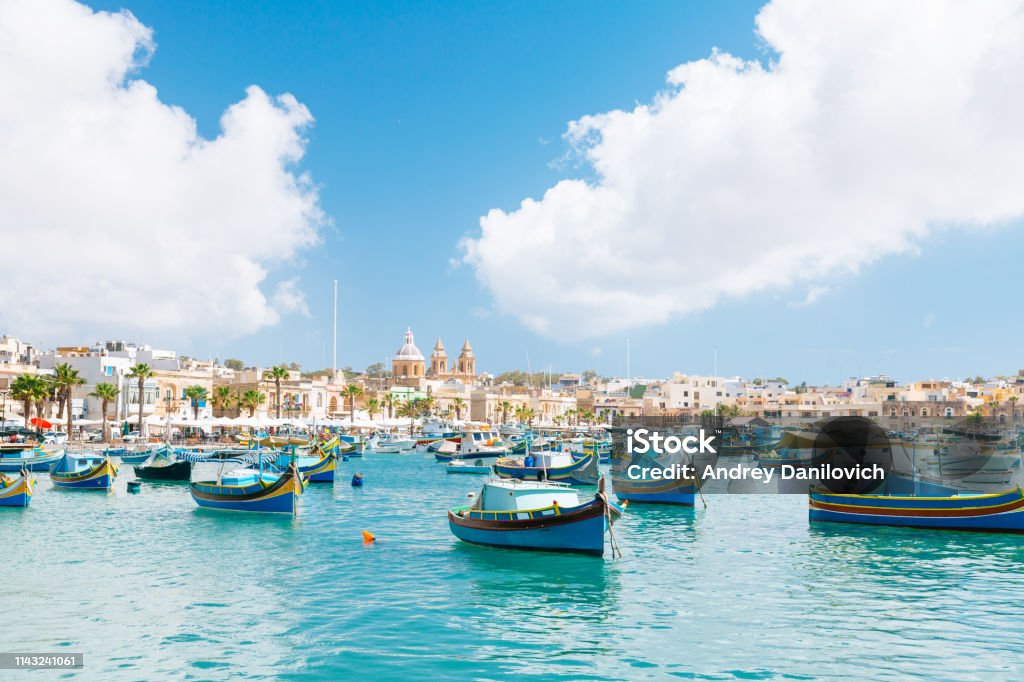 Marsaxlokk Harbor, Malta Colourful boats in Marsaxlokk. Clear sky with few clouds on the background. Malta Stock Photo