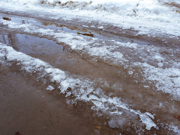 istock Beautiful puddles with ice crust, snow and reflection in winter or spring 1143242426