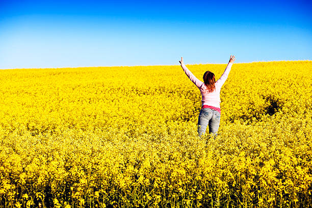 istock Woman jumps for joy in canola field 114324283