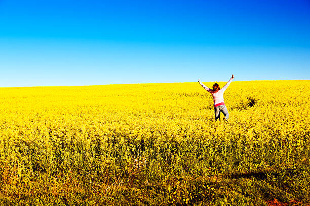 istock Woman jumps for joy in canola field 114324364