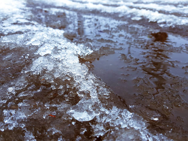 istock Beautiful puddles with ice crust, snow and reflection in winter or spring 1143243977