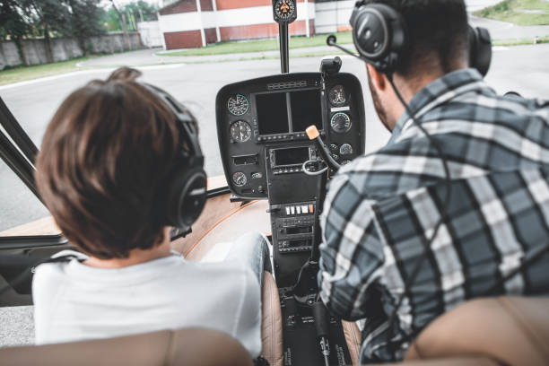 istock Kid and adult sitting inside contemporary helicopter 1143244565