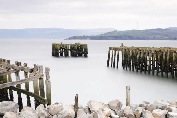 Old derelict wooden jetty pier in sea coast town of Helensburgh Argyll uk