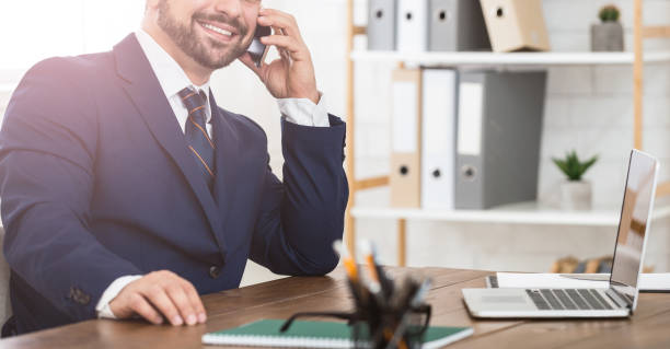 istock Businessman making a call, working on laptop 1143245299