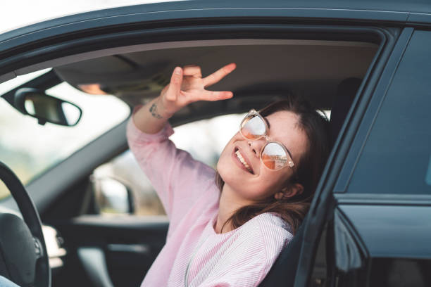 istock Woman sitting on the driver's seat, smiling 1143246759