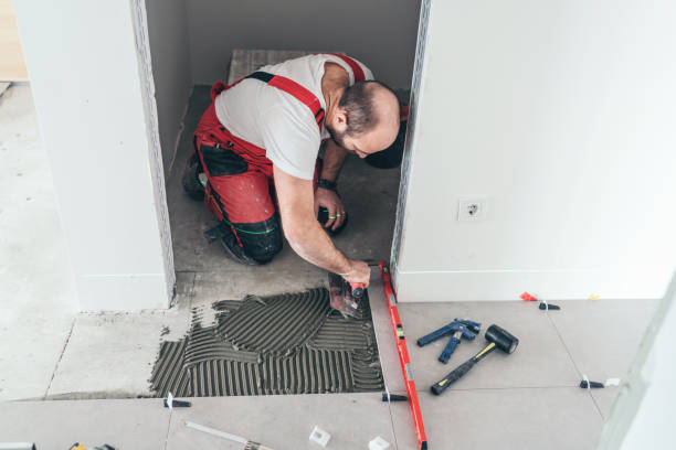 istock Tile worker laying tiles on the floor 1143248581