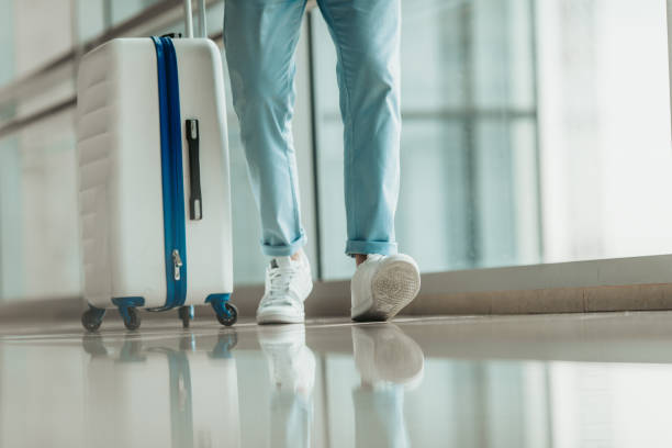 istock Man legs situating near big baggage 1143249909