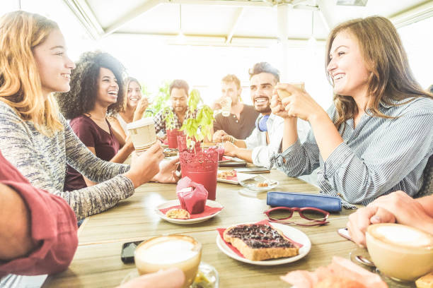 giovani amici che fanno colazione nella caffetteria del bar - persone alla moda felici che bevono caffè e ridono insieme al mattino - pausa lavoro, concetto di cibo e stile di vita - concentrati sul viso della ragazza in basso a destra - muffin blueberry muffin blueberry food foto e immagini stock