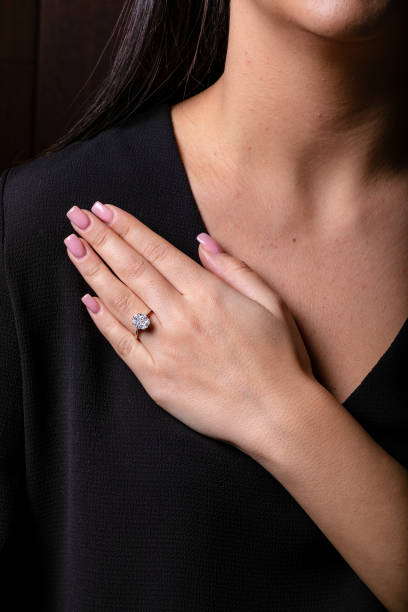 istock Womens silver ring with a diamonds in the middle on finger, on a black background. 1143250570