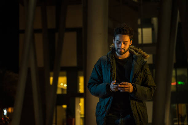 istock Young man text messaging in the city at night 1143250733
