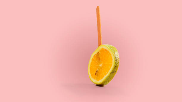 istock sliced orange fruit on a stick. pink background 1143251428
