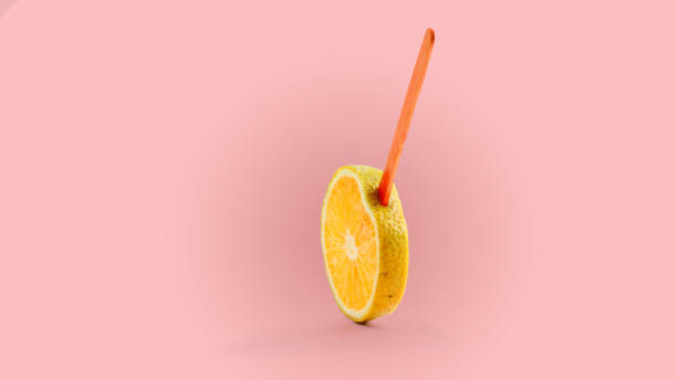 istock sliced orange fruit on a stick. pink background 1143251433