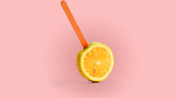 istock sliced orange fruit on a stick. pink background 1143251439