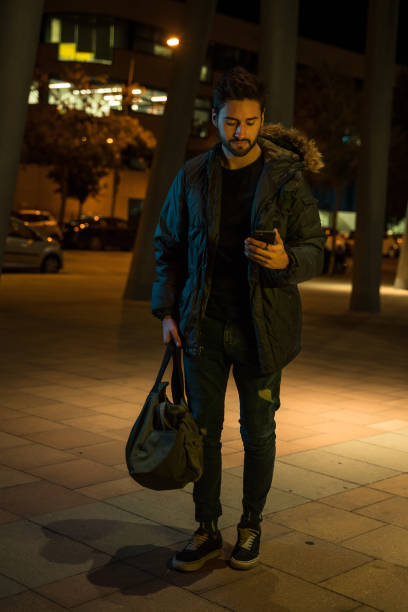 istock Young man looking at smart phone at night 1143253520