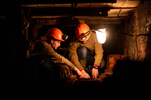 istock Two young guys in a working uniform and protective helmets, sitting in a low tunnel. Workers of the mine 1143253665