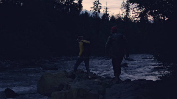 istock Young couple crossing mountain stream together. Night trip 1143253736