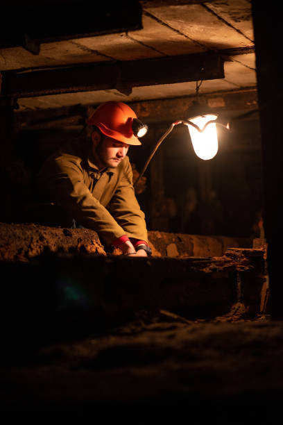 istock young guy in a working uniform and protective helmets, sitting in a low tunnel 1143254148