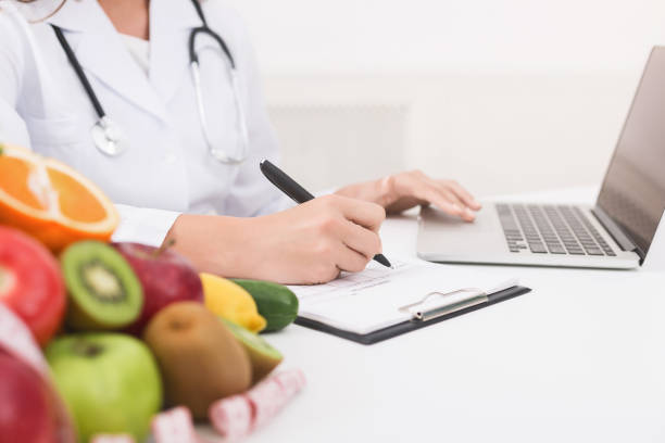 istock Doctor working with laptop and writing on paperwork 1143255281