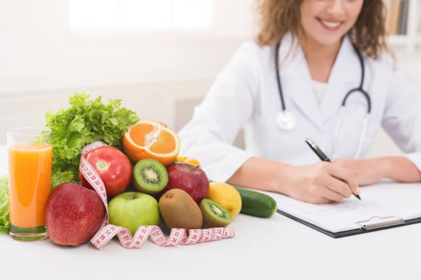 istock Female nutritionist doctor writing vegetable diet plan 1143255416