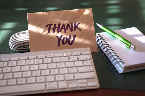 Thank you card inside a brown envelope left on an office table