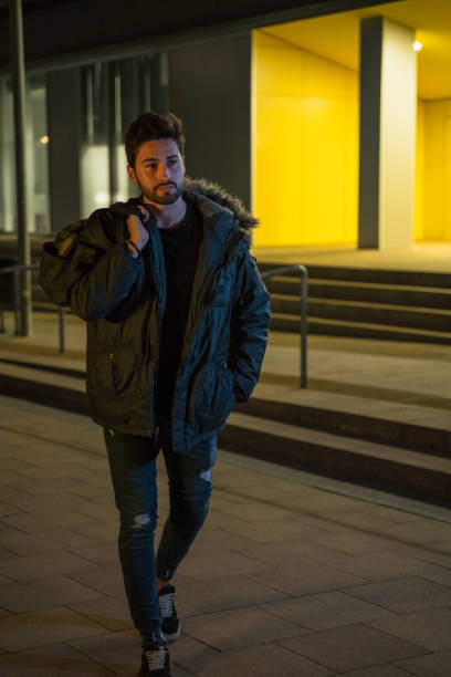 istock Young man carrying a sports bag at night 1143256245