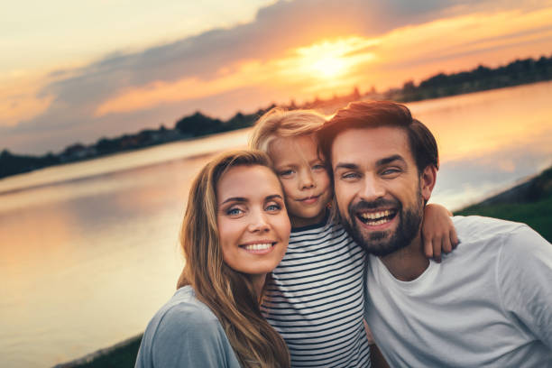 istock Optimistic couple with smiling child resting outdoor 1143256980