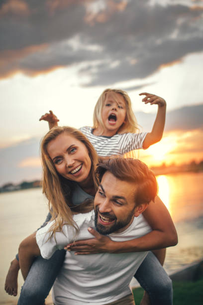 genitori positivi che si divertono con la figlia felice - family portrait foto e immagini stock