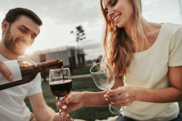 optymistyczny mężczyzna i kobieta pijący wino na zewnątrz - couple dinner summer sunlight zdjęcia i obrazy z banku zdjęć