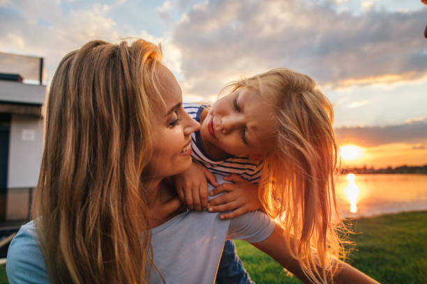istock Positive mom telling with glad child outside 1143257113