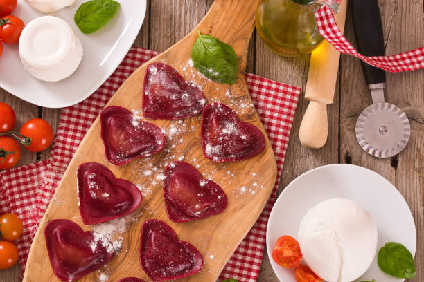 istock Red heart ravioli with tomato, mozzarella and basil. 1143257137