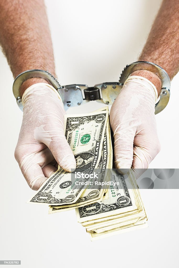 Man's hands handcuffed usando guantes quirúrgica recuentos el dinero - Foto de stock de Dinero libre de derechos