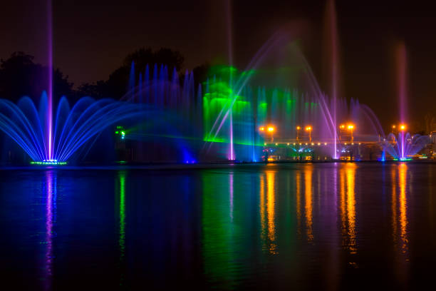Summer night in the city. Fountain on the river with lights