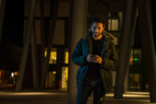 istock Young man text messaging in the city at night 1143259010