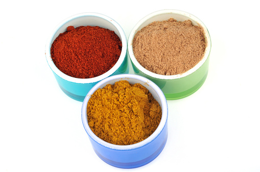 various spices in ramekins on a white background