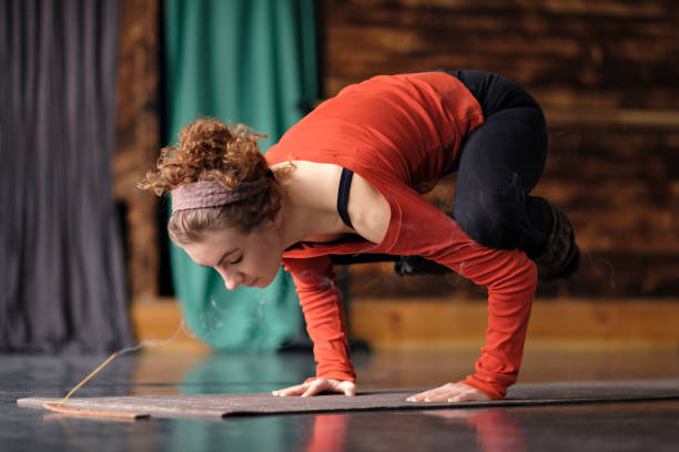 istock Young woman practicing yoga, doing Crane exercise, Bakasana pose, working out. 1143260015