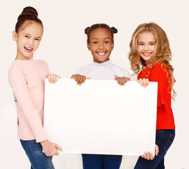 istock Multiracial girls holding blank banner for advertisement 1143260094