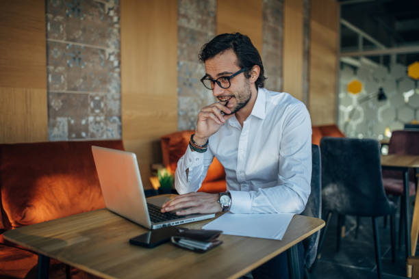 istock Handsome businessman using laptop in cafe 1143263972