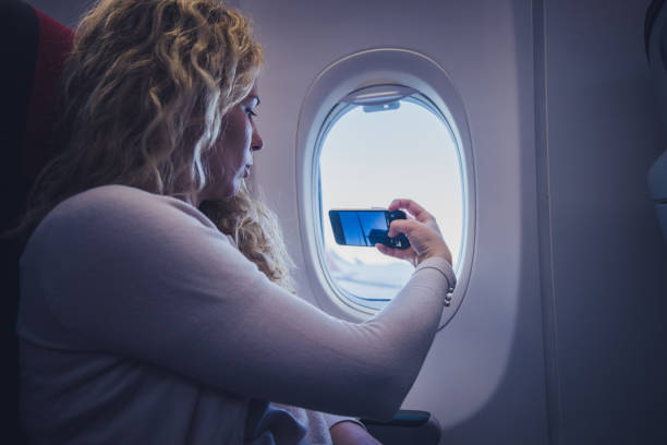 istock Young woman taking a picture from an airplane. 1143264246