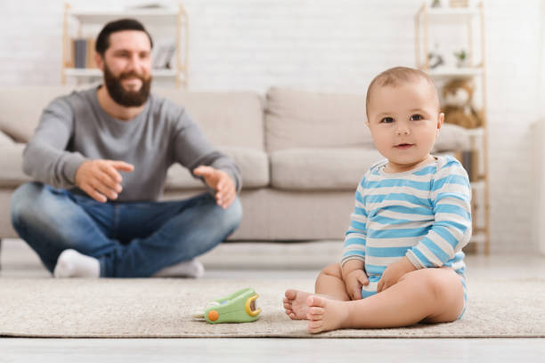 istock Father playing with his baby son on floor at home 1143264407