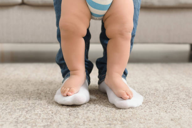 istock Baby boy learning to walk with help of father 1143264423