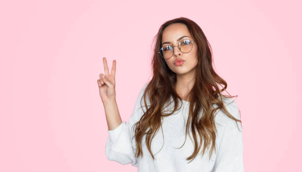 istock Pretty girl pouting lips and showing v-sign 1143265978