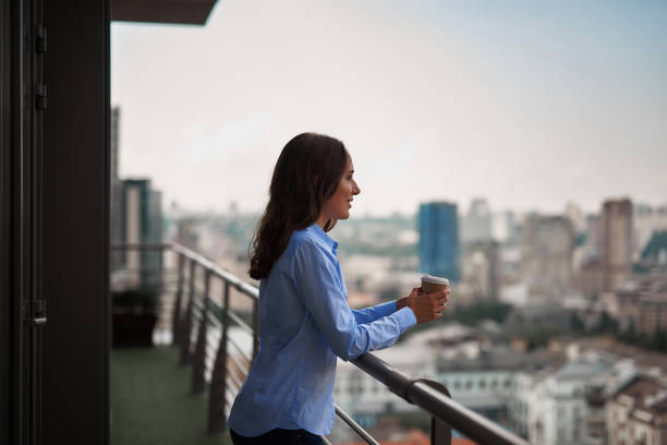istock Female worker drinking coffee on office balcony 1143267590