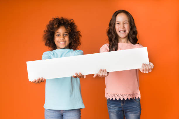 istock Best friends showing blank board, empty banner for your text 1143268861