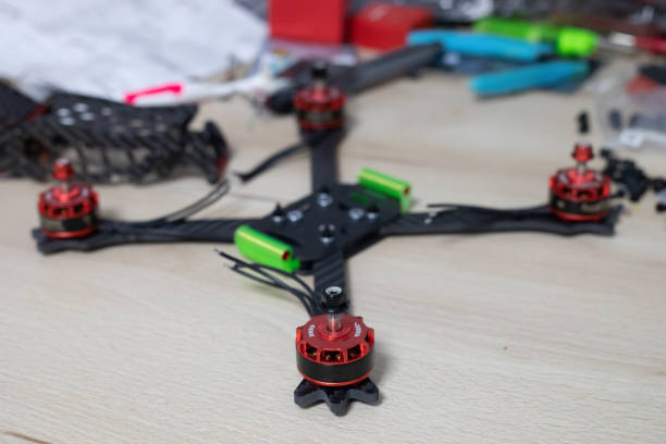 istock Racing drone frame being mounted on wooden table with blurred tools on background 1143268914