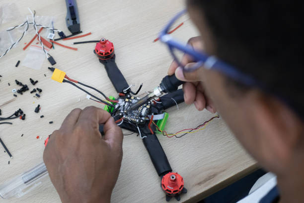 istock Black man mounting and soldering racing drone on wooden table 1143268960