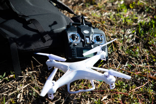 istock White RC drone and black controller on grass near black bag 1143269092